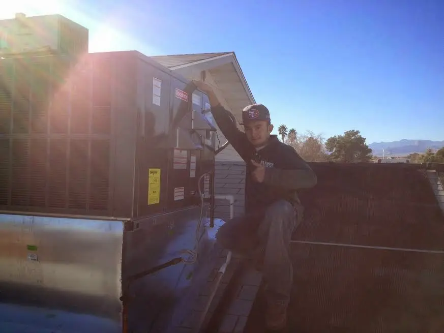 HVAC technician performing AC Tune-Up on a rooftop unit in Grants Pass
